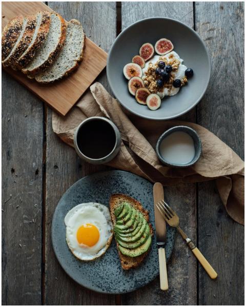 Healthy breakfast with avocado toast, eggs, and yo