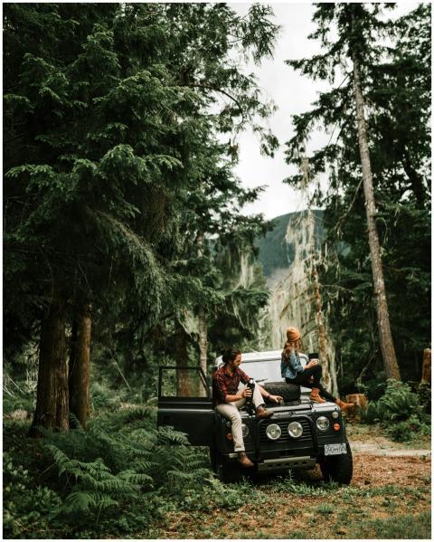 A couple sits on a classic off-road vehicle immers