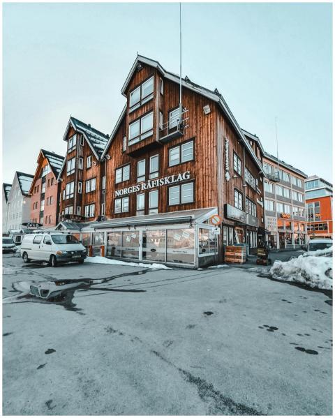 Charming wooden buildings line a snowy street in a