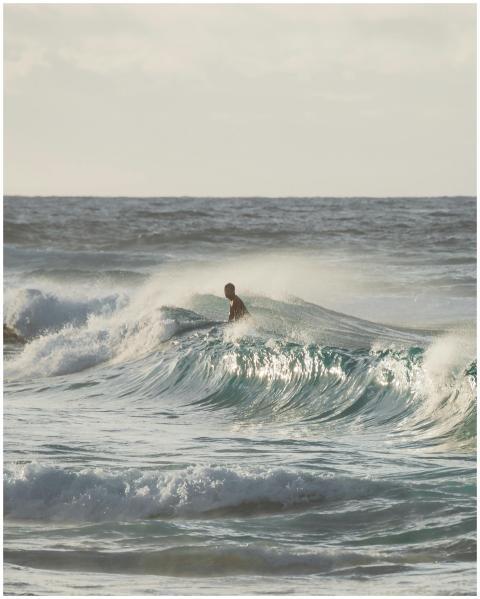 Surfer riding powerful ocean waves, showcasing exh