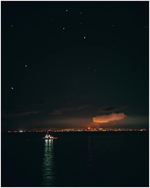 Serene nighttime river view with city lights and s