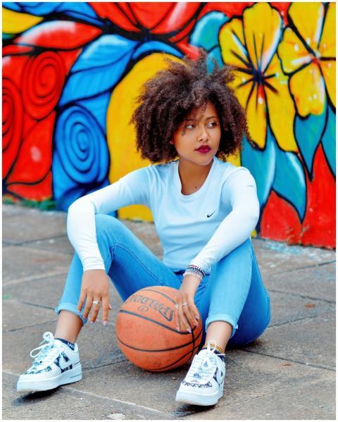 Stylish young woman with afro hair sitting with a