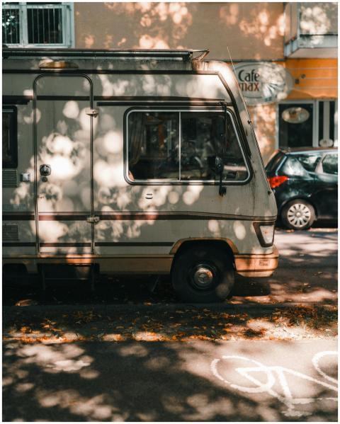 A classic camper van parked on a sunny street, sur