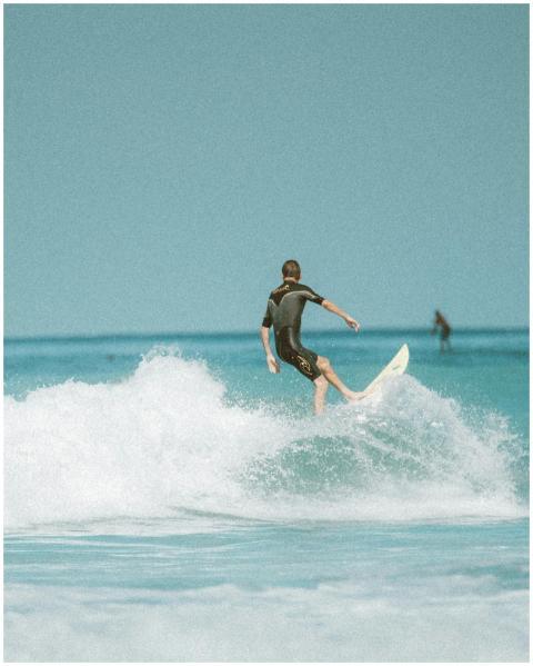 Surfer riding a wave on a sunny day at the beach i