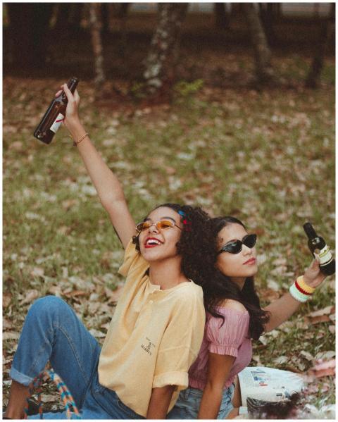 Two women enjoying a fun picnic in the park, raisi
