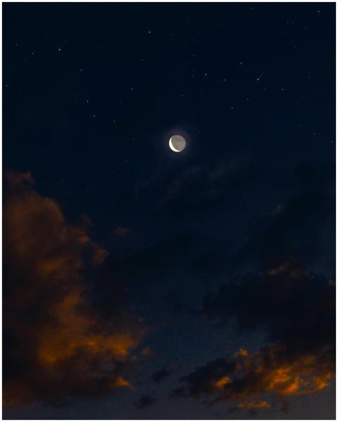 A crescent moon amidst a serene sky full of stars,