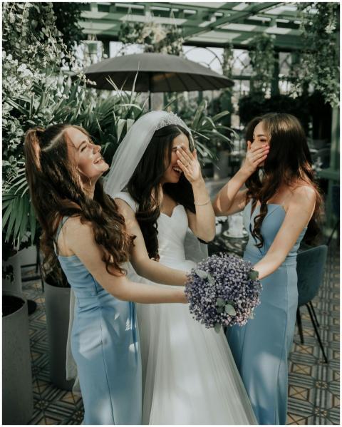 Bride and bridesmaids sharing a joyful moment in a