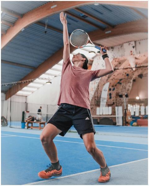 A focused athlete performing a powerful tennis ser