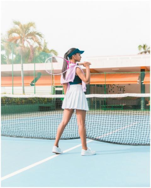 Female tennis player standing on a court holding r