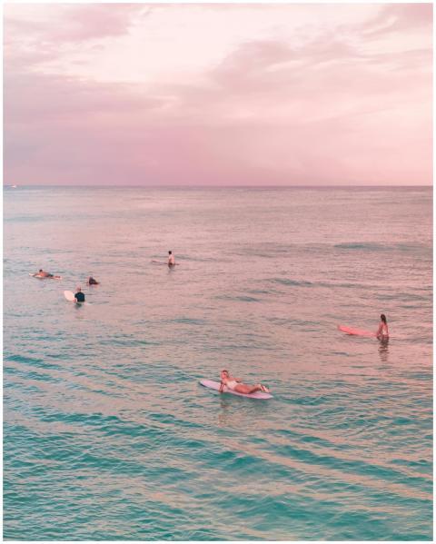 Surfers enjoying a peaceful sunset in Waikiki, Haw