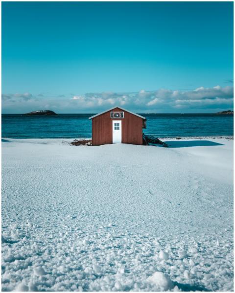 Charming isolated beach hut on a snowy shore with