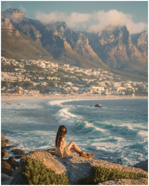 A woman relaxes on rocks overlooking the beautiful