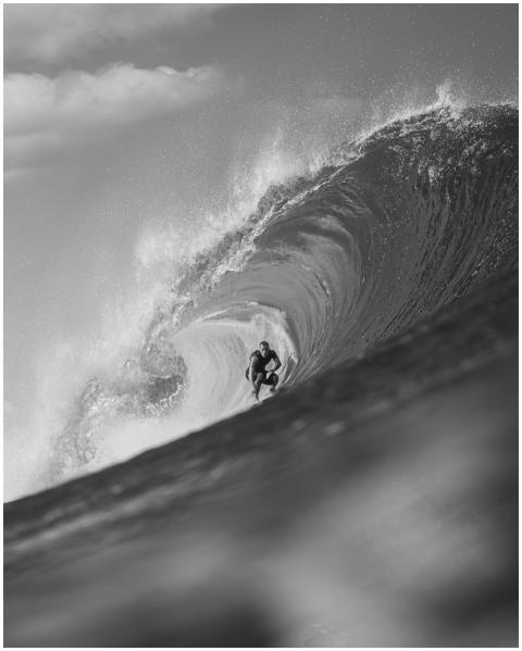 Black and white photo of a surfer skillfully navig