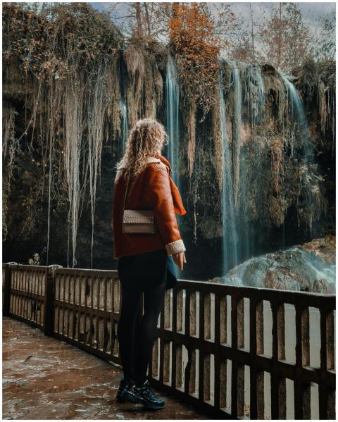 A woman in a brown jacket overlooking a scenic wat
