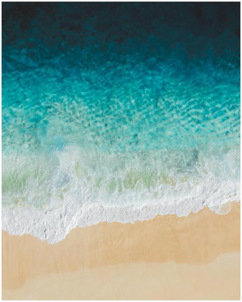 A breathtaking aerial shot of turquoise waves cras