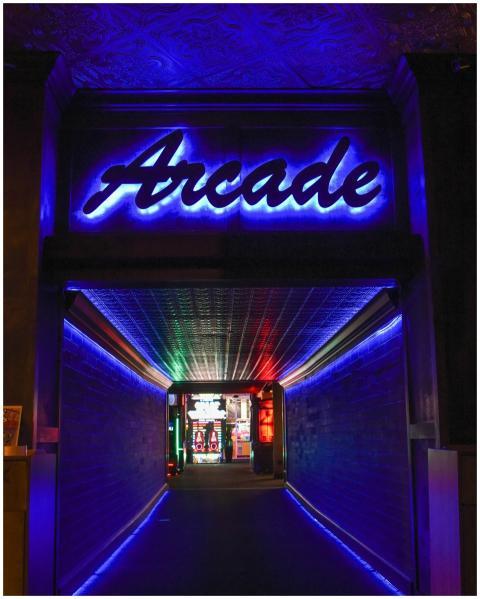 Vibrant neon light hallway leading to retro arcade