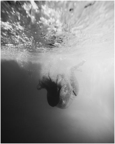 Artistic black and white underwater photo of a wom