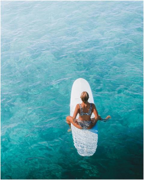 Woman in leopard print bikini surfing on a blue oc