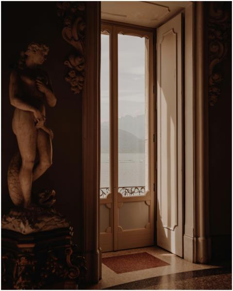 A serene interior with sculpture and lake view in