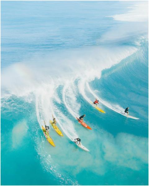 Dynamic aerial photo capturing surfers conquering