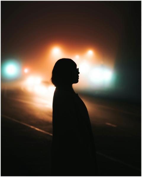 Silhouetted woman standing on an atmospheric foggy