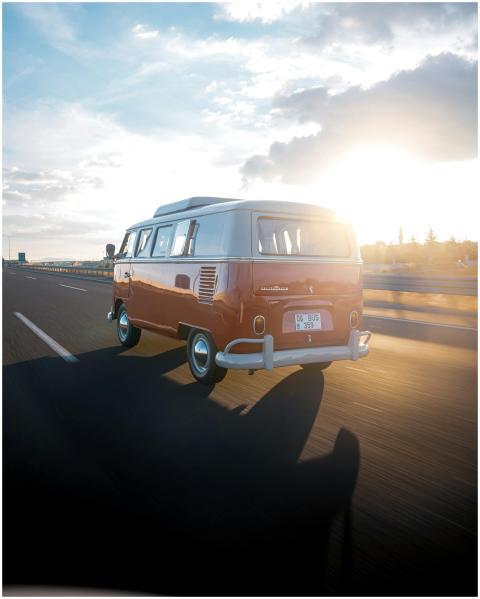 A classic Volkswagen van driving on a highway in A
