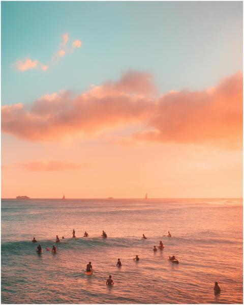 Surfers enjoy a breathtaking sunset at the beach i