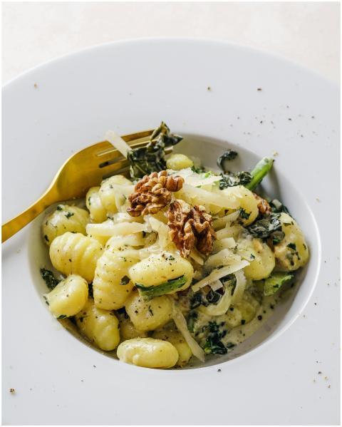 Elegant plate of gnocchi pasta topped with kale an