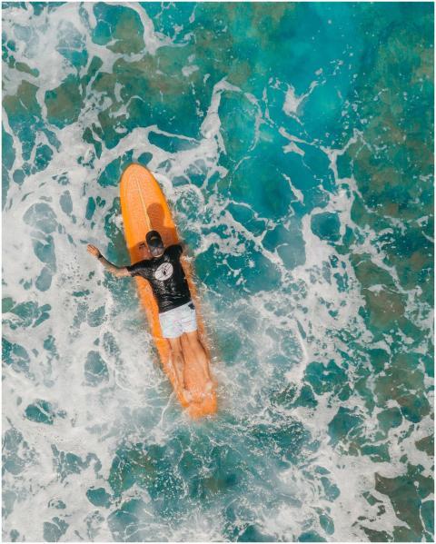 Top view of a person surfing on vibrant turquoise