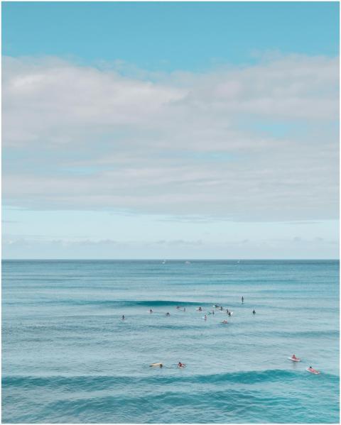A tranquil coastal view with surfers in the ocean