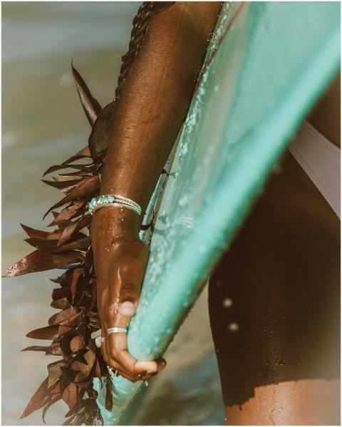 Close-up of a woman holding a surfboard in the oce