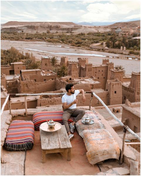 Man enjoying tea on a rooftop terrace overlooking