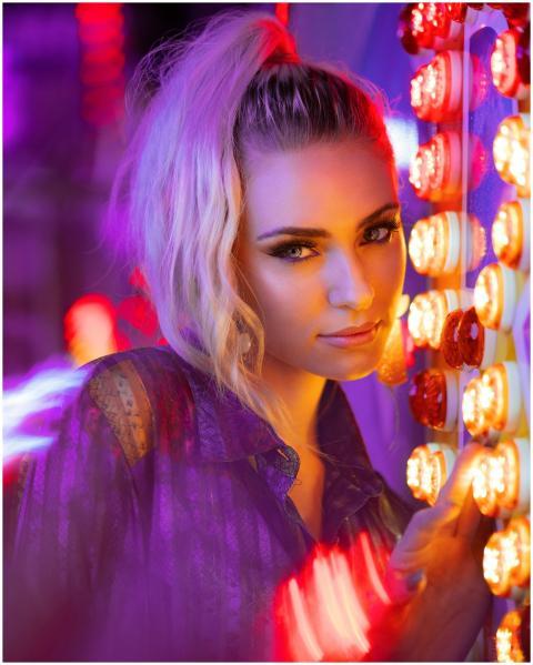 Portrait of a young woman with vibrant neon lights