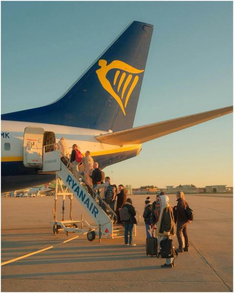 Travelers board a Ryanair plane at sunset in Porto