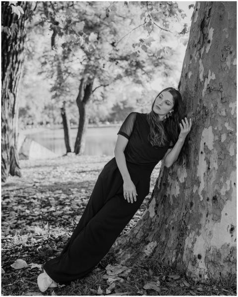Black and white portrait of a woman leaning agains