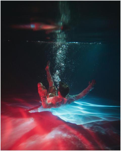 A diver in dynamic pose underwater with vibrant re
