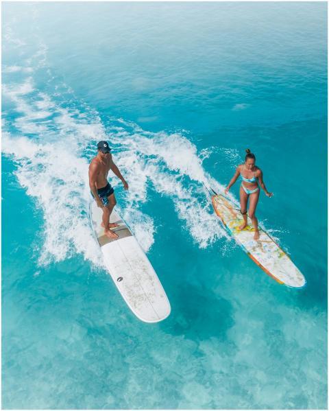 Dynamic aerial photo of a man and woman surfing vi