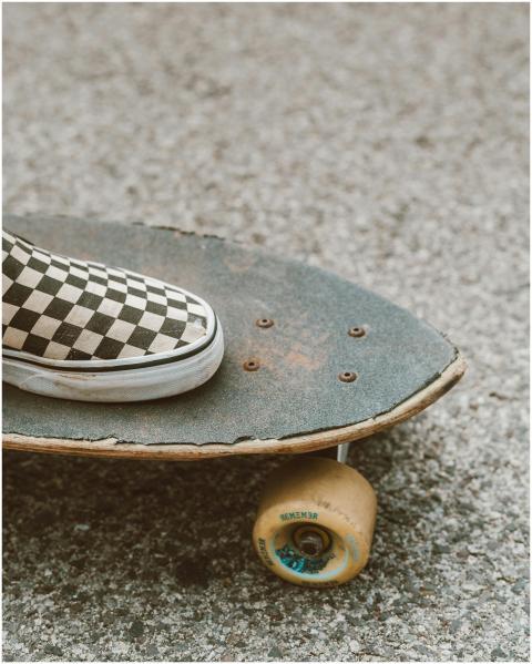 Close-up of a checkered shoe on a skateboard outdo