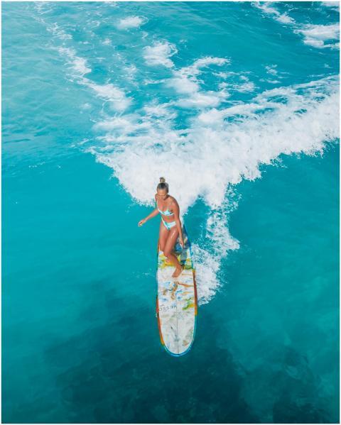 High-angle view of a woman surfing on a colorful b