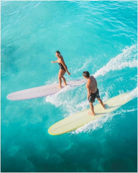 Dynamic aerial photo of male and female surfers gl