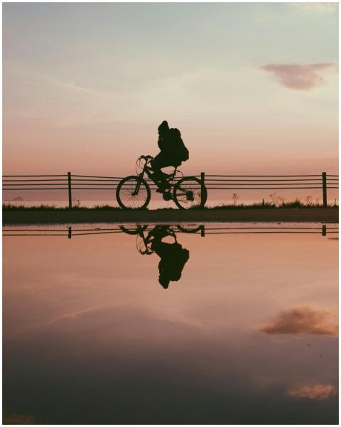 Silhouette of a cyclist with a reflection during a
