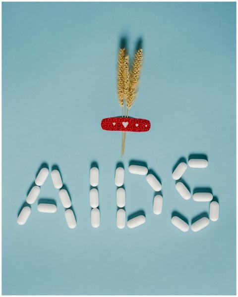 Pills arranged to spell AIDS with bandaid and whea