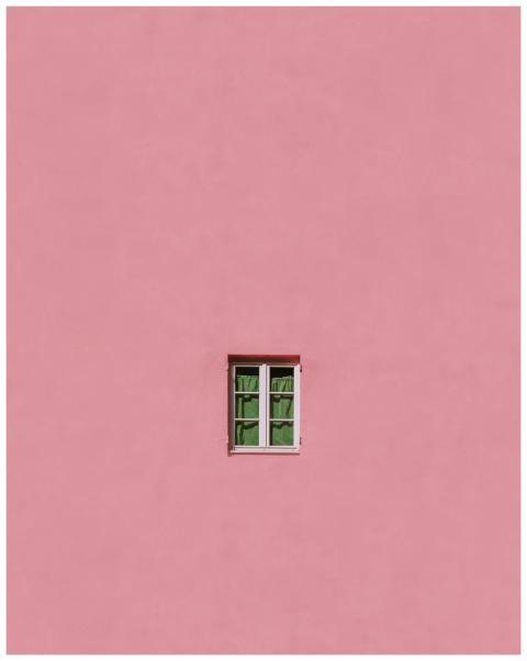 A single window on a vibrant pink wall exemplifies