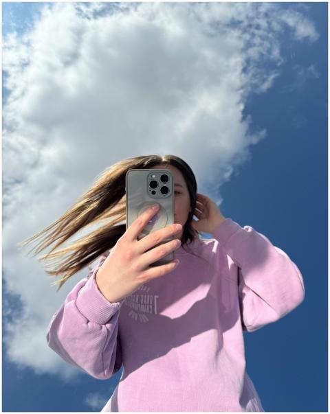 Confident young woman in lavender sweater taking a