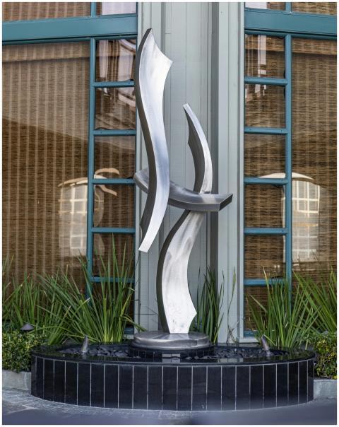 Modern sculpture with sleek curves set against a b