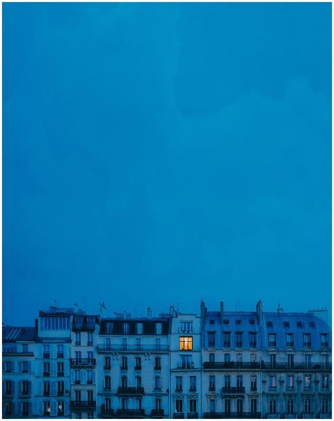 A single illuminated window stands out in an eveni