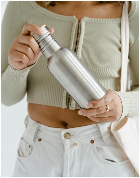 Person holding a reusable stainless steel water bo