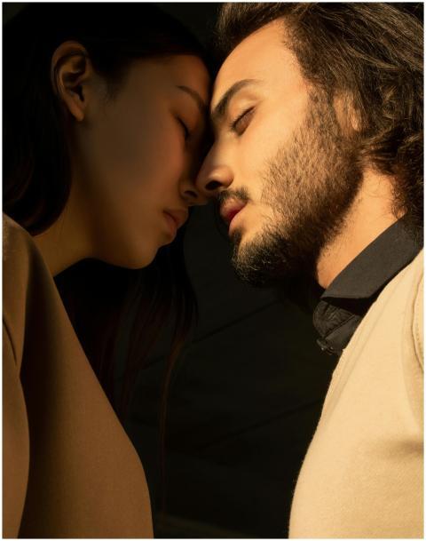 A close portrait of a couple with closed eyes shar