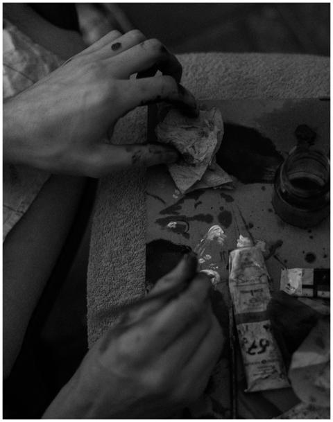 Close-up of hands painting in black and white, sho