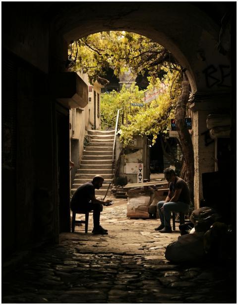 Two people silhouetted in an archway with cobblest